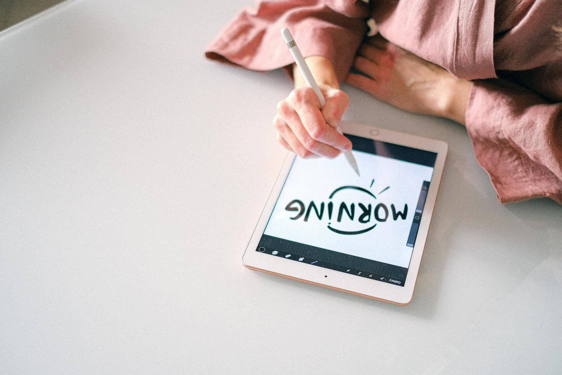 Osoba pisze rysikiem na tablecie, korzystając z aplikacji do notatek