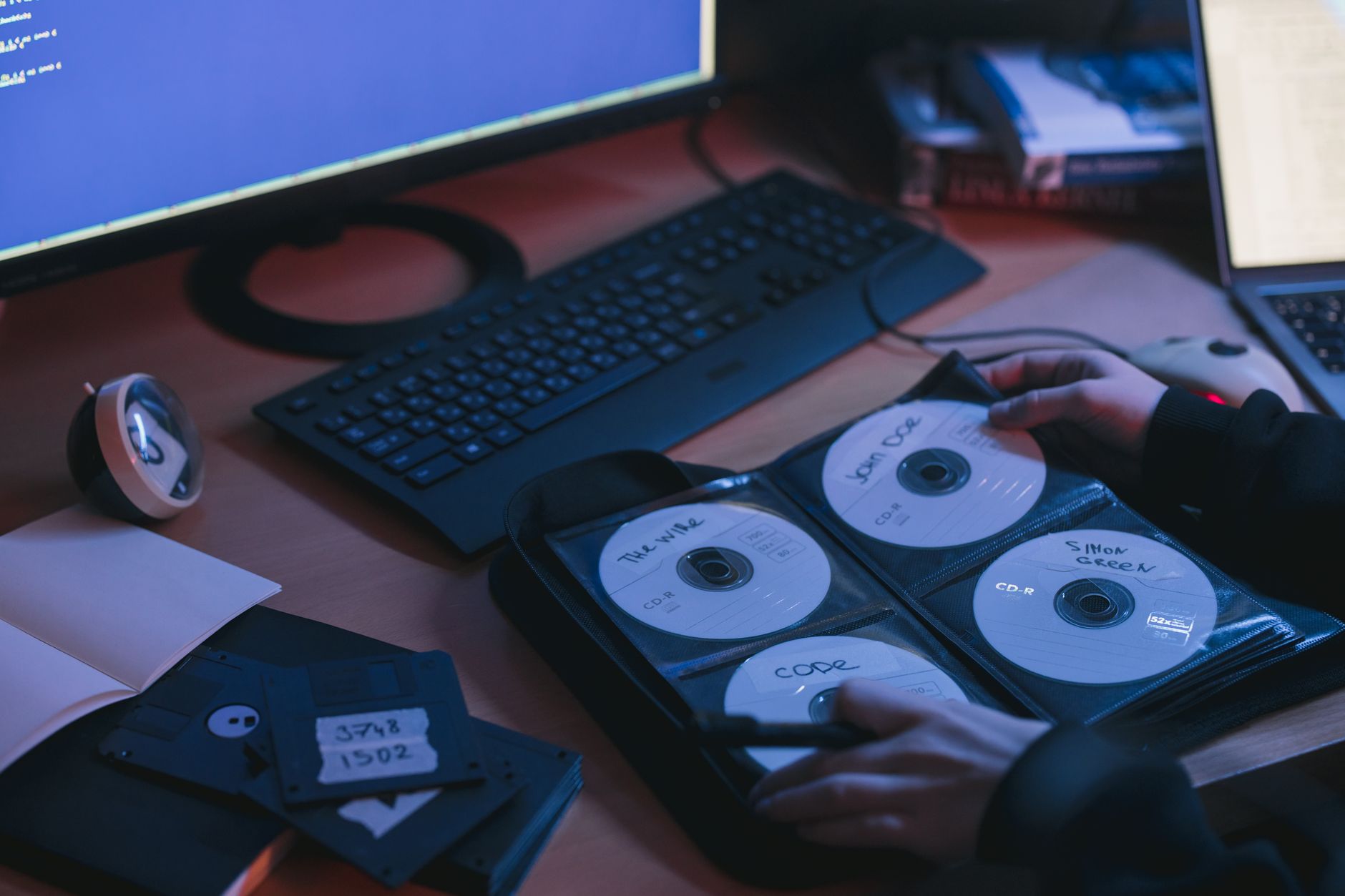 Płyty CD na biurku w biurze IT jako metafora pirackiego oprogramowania Płyty CD na biurku w biurze IT jako metafora pirackiego oprogramowania