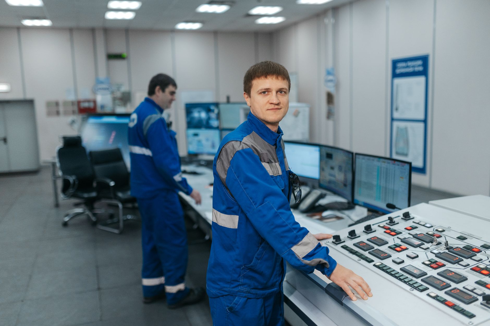 Dwaj technicy obsługują maszyny w nowoczesnej sterowni przemysłowej