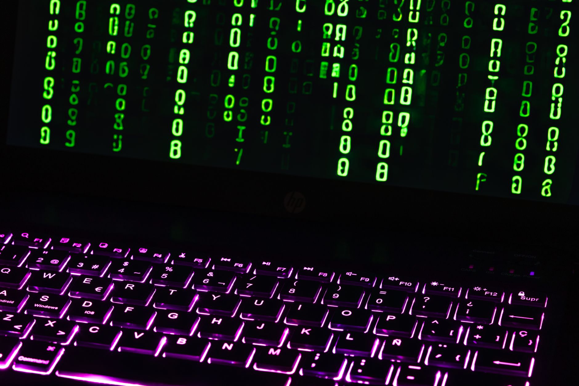 Podświetlona klawiatura laptopa i zielony kod na ekranie